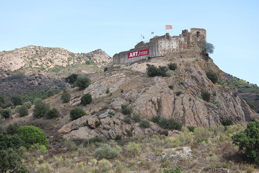 Le drapeau géant de ArtUnits accroché aux murs extérieurs d'un château espagnol comme symbole de l'arti qui unit