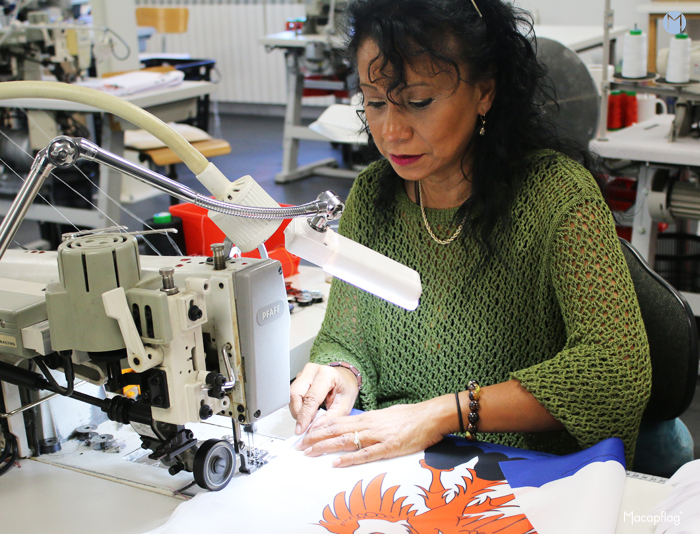 Ghislaine, chef de l'atelier confection chez Macap devant l'une de ses machines