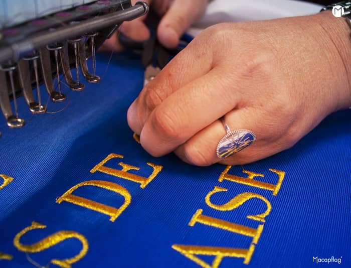 Broderie de lettres or sur un drapeau de prestige